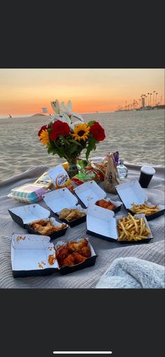 a table topped with lots of food next to the ocean