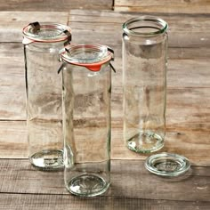 three empty glass jars sitting on top of a wooden table