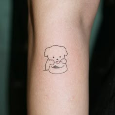 a small tattoo on the arm of a woman with a teddy bear holding a cup