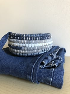 stack of blue jeans stacked on top of each other next to a pair of folded towels