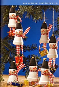 snowmen are hanging from the branches of a christmas tree