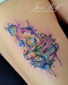 a woman's thigh with watercolor tattoos on her legs and the image of a stack of books