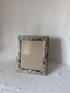 a silver frame sitting on top of a white sheet