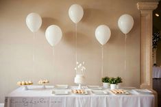 a table topped with lots of white balloons