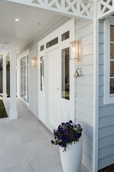 a large white planter sitting on the side of a house next to a door