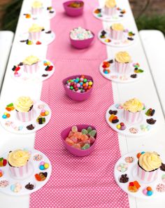 a table topped with lots of cupcakes and candy