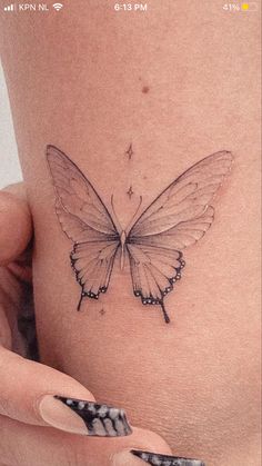 a woman's stomach with a small butterfly tattoo on the side of her belly