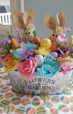 an easter basket with flowers and bunnies in it