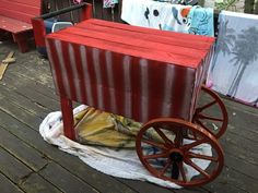 a red wagon sitting on top of a wooden deck