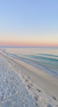 the beach is covered in white sand and footprints