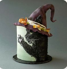 a cake decorated to look like a witch's hat with cats and pumpkins on top