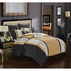 a bed with black and gold comforters in a room