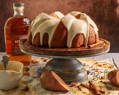 a bundt cake sitting on top of a table next to a bottle of alcohol