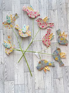 a bunch of paper butterflies sitting on top of a wooden floor