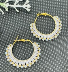 "This beadwork project is a pair of lovely  hoop white and gold plated earrings. They measure about 1.75\" long from the top of the ear wire to the bottom beads.  These were designed and beaded be me in my smoke free studio." White Wire Wrapped Dangle Hoop Earrings, Gold Beaded Hoop Earrings, Small Hoop Earrings With Dangling Beads For Party, Gold Beaded Hoop Earrings For Party, Gold Hoop Earrings With Beads For Party, Handmade White Crystal Round Earrings, Handmade White Crystal Earrings, Small Hoop Beaded Earrings For Party, Gold Hoop Beaded Earrings For Pierced Ears