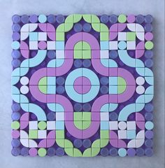 a purple, green and blue tile with circles in the center on a white surface