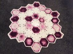 a crocheted doily with pink and white hexagons on it