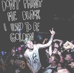 a group of people at a concert with the words don't paint me black i used to be golden