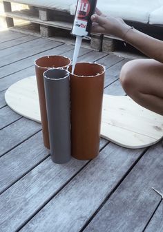 a person kneeling down on the ground with two different colored cups in front of them