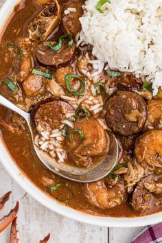 a white bowl filled with shrimp and rice next to a spoon on top of it