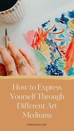 a woman's hand holding a pen and writing on paper with the words how to express yourself through different art mediums