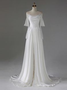 a white wedding dress on a mannequin with long sleeves and an open back