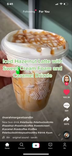 someone holding up a cup of ice cream with caramel drizzle on it