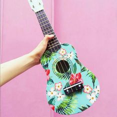 a person holding a ukulele in front of a pink background with the words, ukulele summer festival