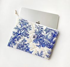 a blue and white toiler print pouch with an apple laptop in the background