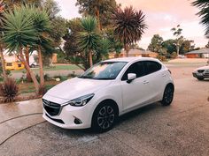 a white car is parked on the street