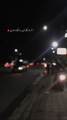 blurry image of cars driving down the street at night with words written in arabic