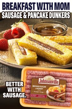 sausage and pancake dunkers are on a plate with strawberries next to them