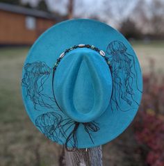 This truly one-of-a-kind hand burnt fedora is perfect to add a stylish nautical flare to your outfit or hang as a unique ocean inspired wall decoration. It's burned entirely by hand using a pyrography tool with an original and entirely freehanded design (never using a stencil or laser machine.) The vibrant turquoise faux suede material burns a gorgeous deep shade of teal. This design features jellyfish swimming across the top brim of the hat. I adjusted the woodburner to different temperatures t Jellyfish Hat, Beaded Seashell, Realistic Shading, Jellyfish Swimming, Rodeo Mom, Pyrography Tools, Hat Inspiration, Marine Biologist, Nautical Gifts