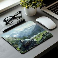 a mouse pad sitting on top of a desk next to a laptop computer and eyeglasses