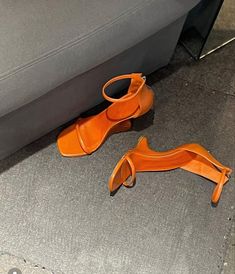 an orange pair of shoes sitting on the floor