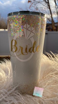 the bride glitter tumbler is sitting on some fur