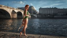 a woman in a green bathing suit standing by the water