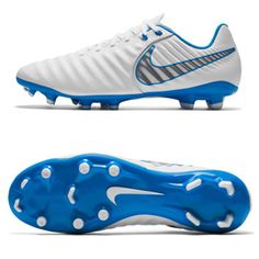 a pair of white and blue soccer cleats with spikes on the soles