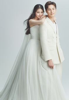 a man and woman in wedding clothes posing for the camera with their arms around each other