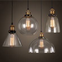 three clear glass pendant lights hanging from a ceiling fixture with one light bulb turned on