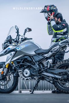 a man standing next to a parked motorcycle