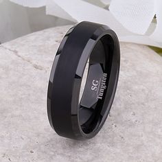 a black ceramic ring sitting on top of a rock