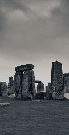 stonehenge in the middle of a field under a cloudy sky