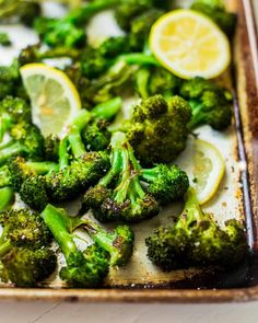 broccoli florets and lemon slices on a baking sheet