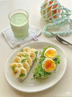 a white plate topped with food next to a glass of green juice