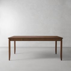 a wooden table sitting on top of a white floor next to a gray wall in an empty room