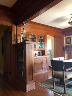 a dining room with wood paneling and built in cabinets