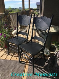 two black chairs sitting on top of a porch