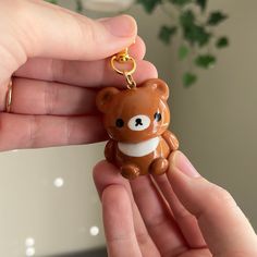 a person holding a brown bear keychain in their hand