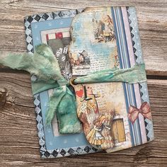 an altered photo album with a bow tied to it's side on a wooden surface